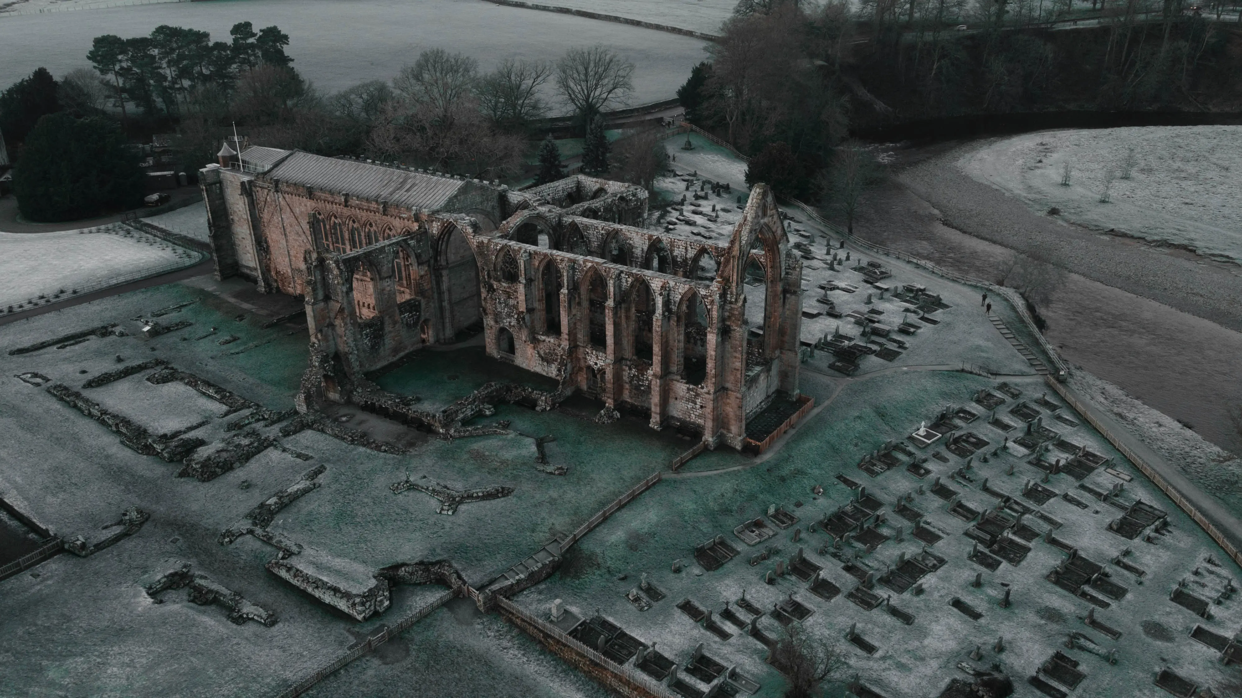 Aerial view of frost covered ruins of Bolton Abbey priory in winter morning mist